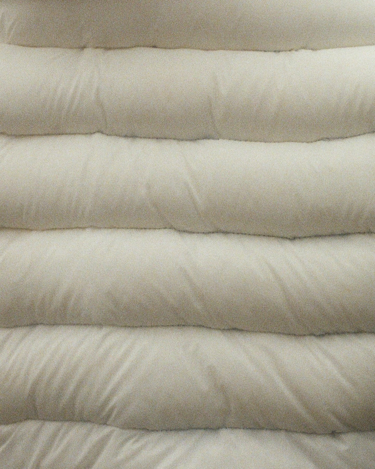 Close-up of the cocoon anorak's quilted baffles in translucent white.